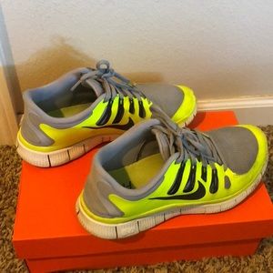 Bright yellow and gray Nike running shoes.